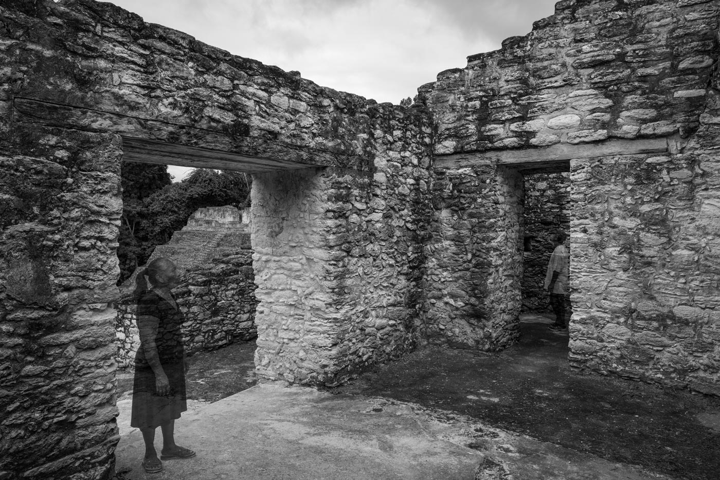 Two translucent Maya visitors inside the stone rooms of Caracol